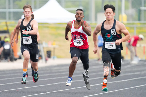 Three young men in hot competition during a track event at Dairyland Games