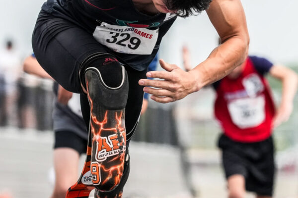 An adaptive track athlete poised in the starting block before a race