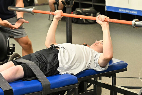 A participant performing a bench press as part of the Dairyland Sports Fitness Foundations program