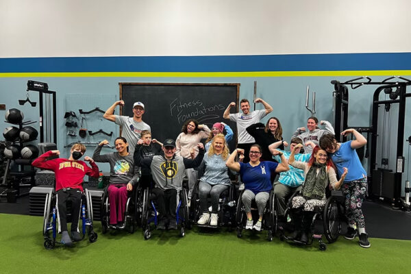 A group of Fitness Foundations program participants flex for a photo