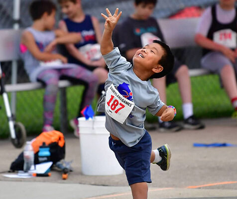 An adaptive competitor shortly after releasing a shot put during a field event